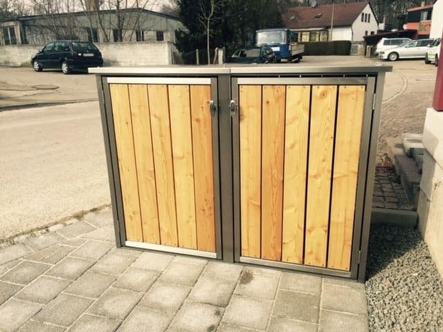 Hier sehen Sie eine Mülltonnenbox aus Lärche, die straßennah aufgestellt ist. Der Zugang für die Müllabfuhr ist perfekt.